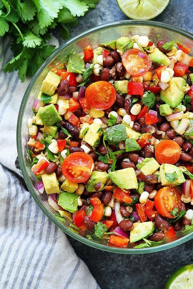 Black Bean Salad with avocado and tomatoes in glass bowl. 
