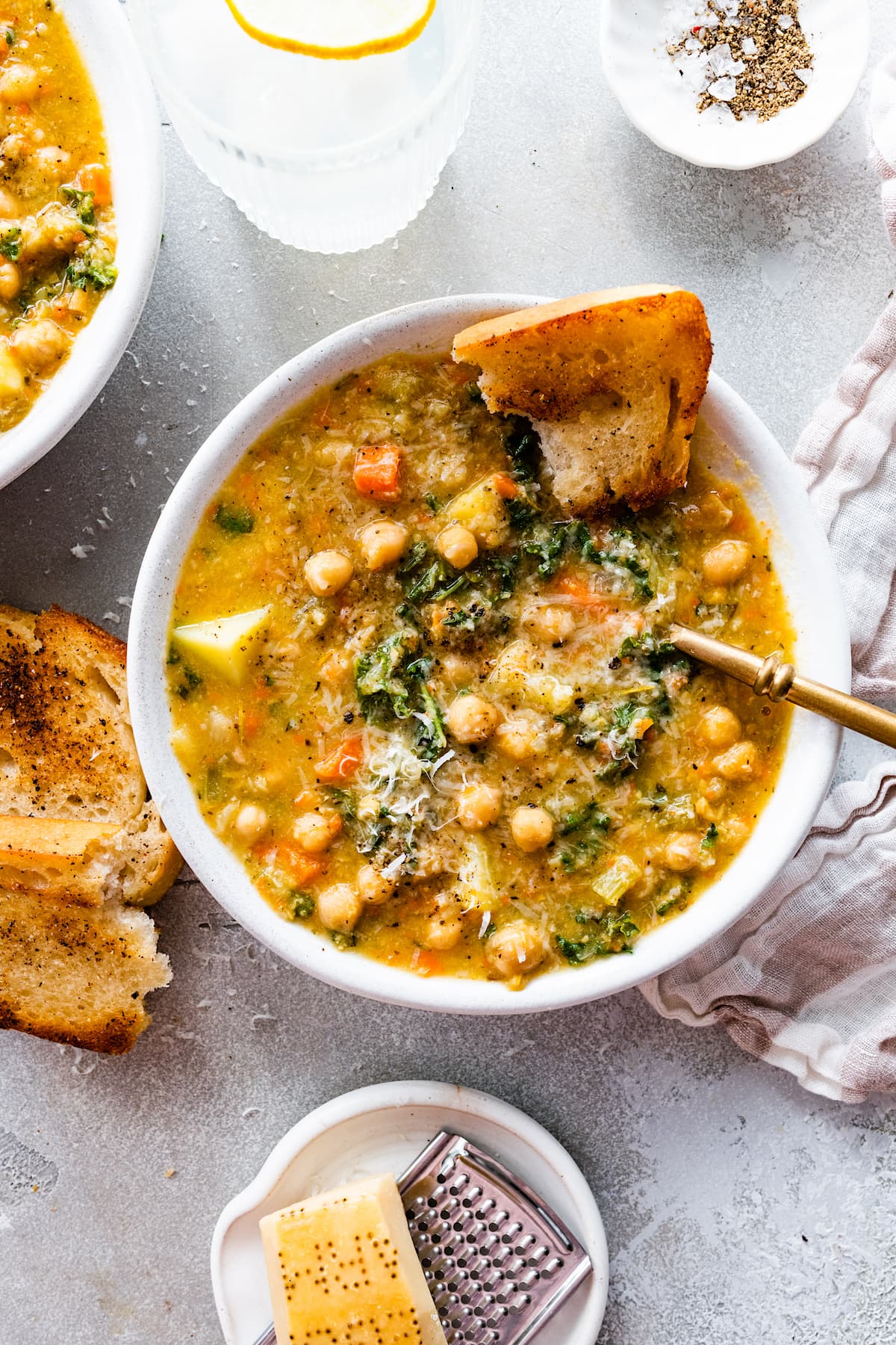 chickpea soup in bowl with spoon and crusty bread. 