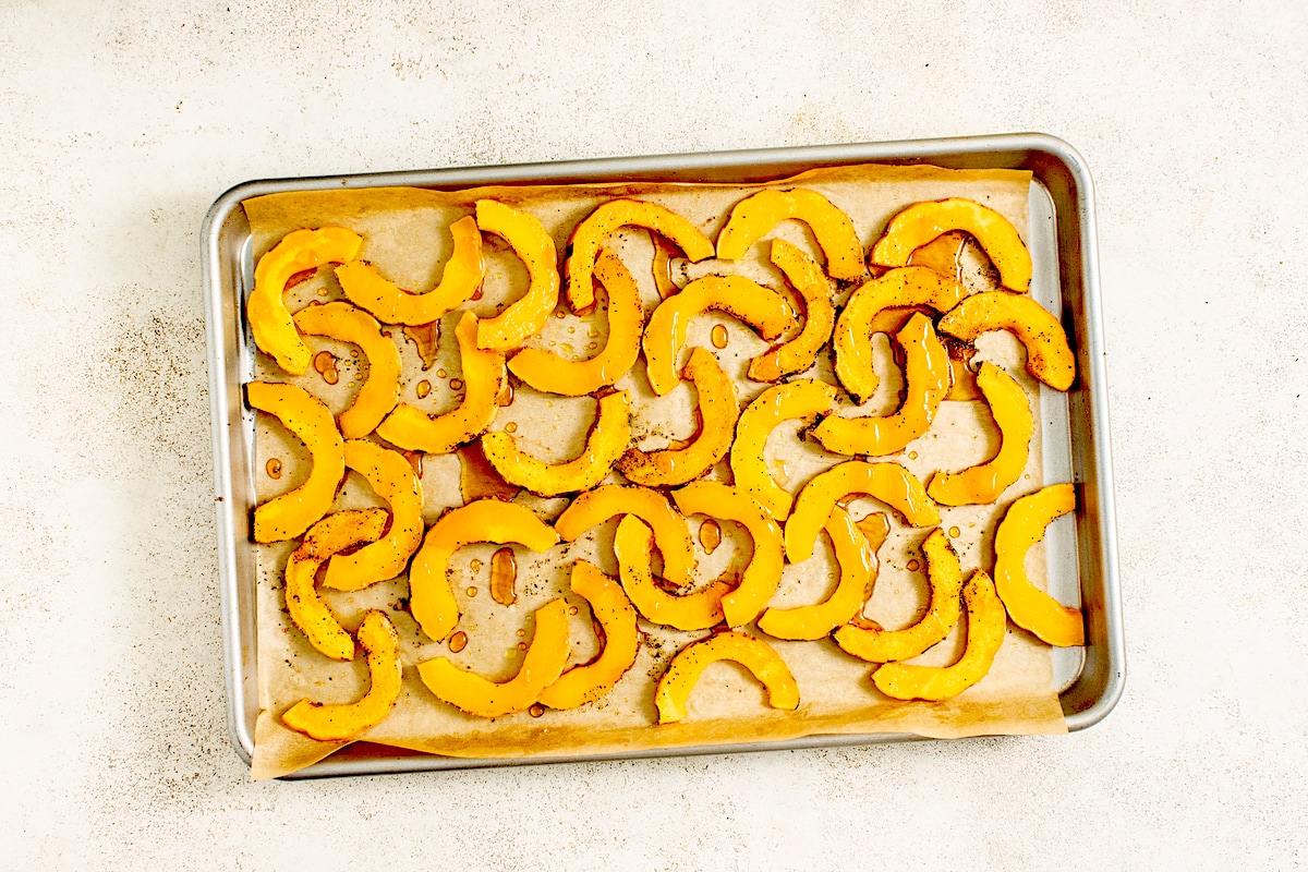 roasted delicata squash on pan with parchment paper. 