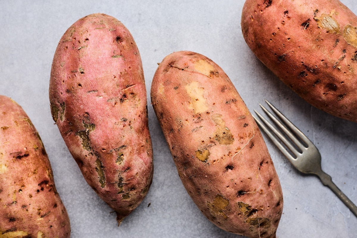 sweet potatoes being pricked with a fork. 